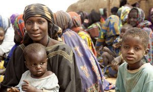 A Malian refugee mother with her children wait to receive relief items in Gaoudel, Ayorou district, northern Niger.