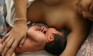 A woman breastfeeds her child.