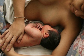 A woman breastfeeds her child.