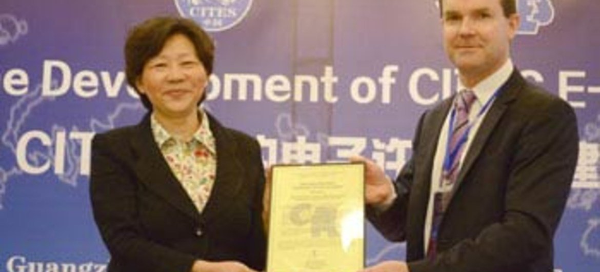 John E. Scanlon (right), CITES Secretary-General, presents Certificate of Commendation to Yin Hong, Vice Aministrator of State Forestry Administration in China.