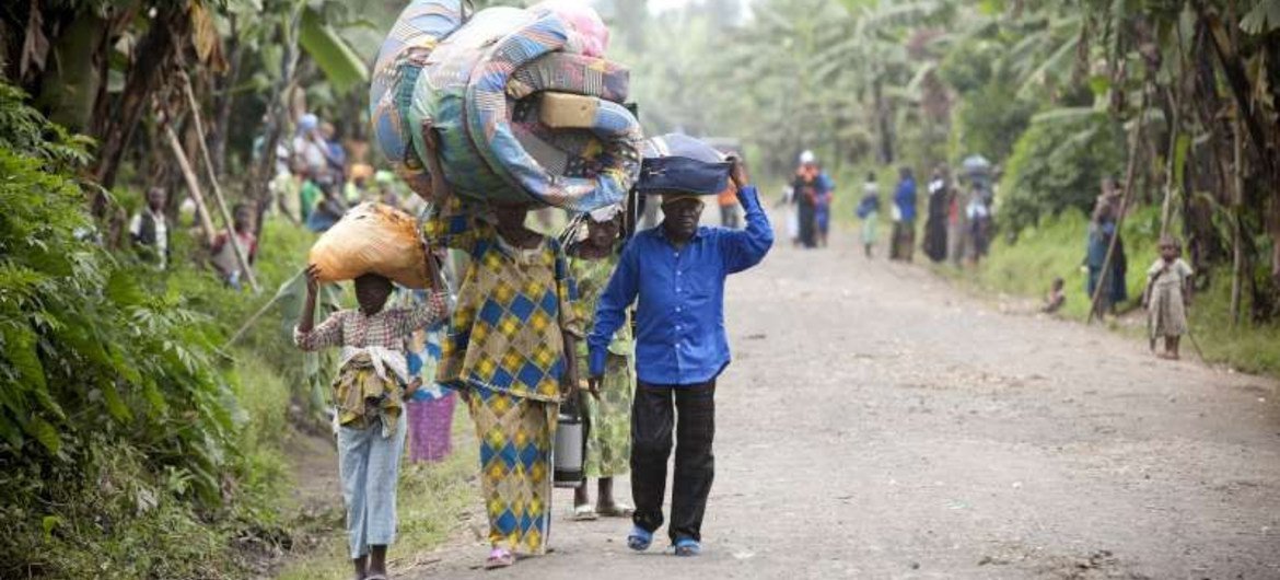 Congolese civilians carry their belongings as they escape recent fighting in Rutshuru.