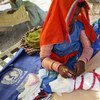 A woman swaddles her crying newborn in a camp in southern Pakistan.