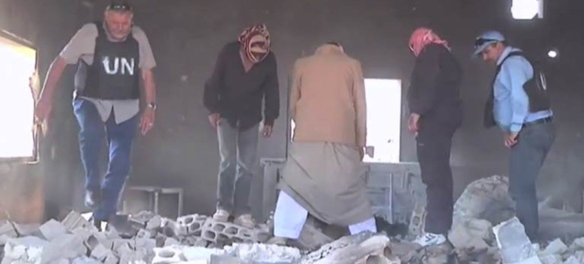 Des observateurs des Nations Unies et des résidents fouillent des décombres dans le village syrien de Mazraat al-Qubeir, près de Hama.