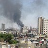 Smoke drifts into the sky from buildings and houses hit by shelling in Homs, Syria (June 2012).