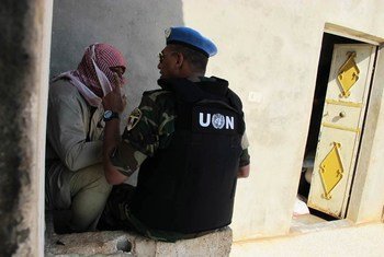 An observer with the UN Supervision in Syria interviews a local man while conducting a fact-finding mission in the village of Mazraat al-Qubeir.