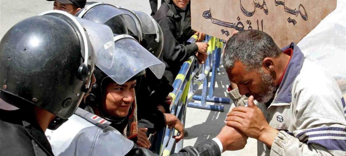 Des militants manifestent contre les brutalités policières en Egypte. L'un d'entre eux brandit une pancarte sur laquelle est écrit: "Votre travail est nous protéger, pas de nous torturer."