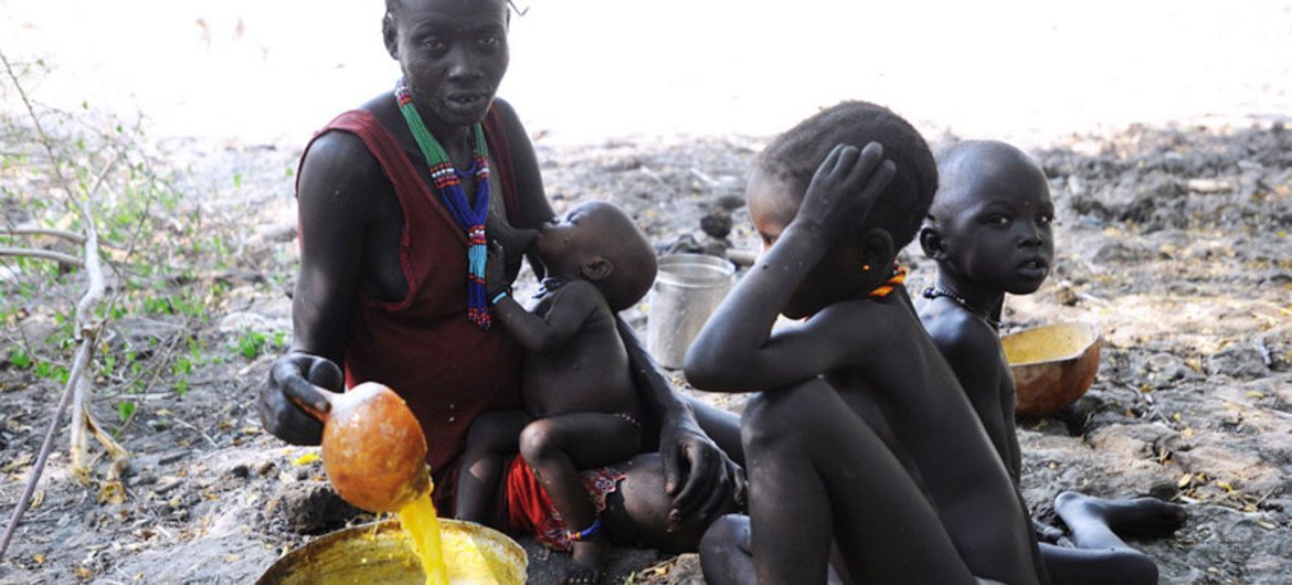 A mother prepares a meal for her children on the outskirts of Fertait, a village in Jonglei which was burned during the ethnic clashes.