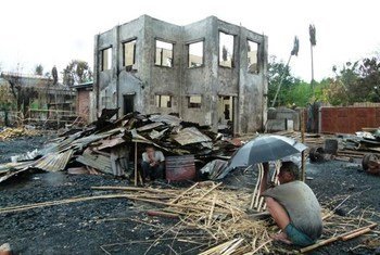 Two men sit under the the remnants of their homes in Sittwe, the provincial capital of Myanmar's western Rakhine State.