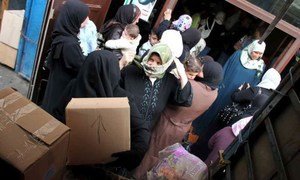 Syrian refugees receive supplies from UNHCR in northern Lebanon.