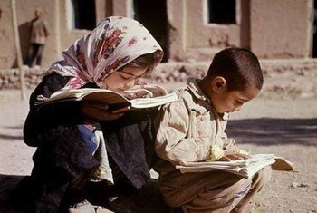 Young boy and girl reading books in a street in Qazvin, Iran.