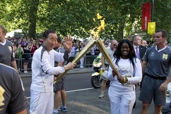 Secretary-General Ban Ki-moon (left) takes part in the torch run for the 2012 Summer Olympic Games in London.