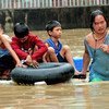 Four young children are rescued with the use of inner tubes at a flooded riverside community in Manila.