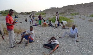 Exhausted new arrivals recover on a beach after crossing the ocean to southern Yemen.