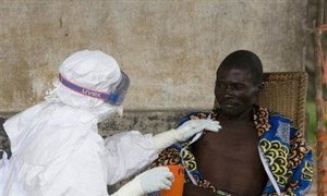 Une infirmière de MSF conforte un patient atteint du virus Ebola à Kampungu en RDC.
