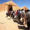 Syrian refugees queue for relief items at Jordan's Za'atri camp.