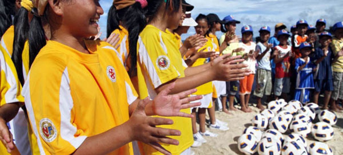 Children attending a soccer demonstration in a community helped by FAO and the Asian Football Confederation (AFC).