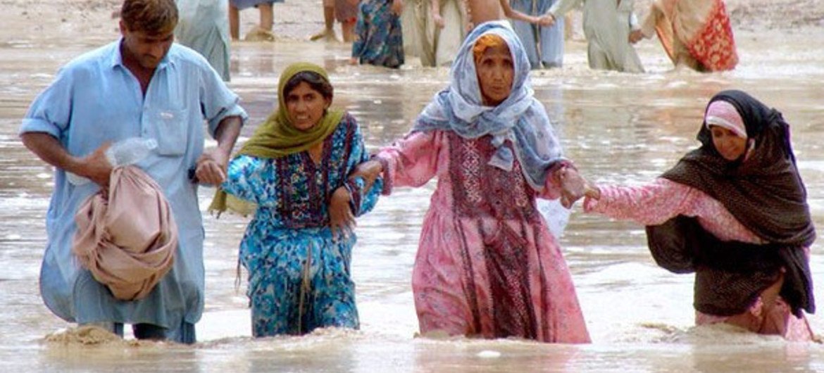 Des Pakistanaise se fraient un chemin au milieu des inondations dans le district de Jaffarabad et de Nasirabad, au Baloutchistan.