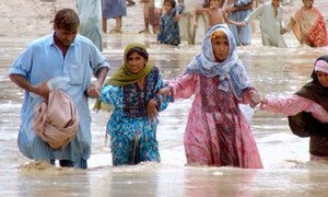 People wade through the flood waters in the district Jaffarabad and Nasirabad, Balochistan.