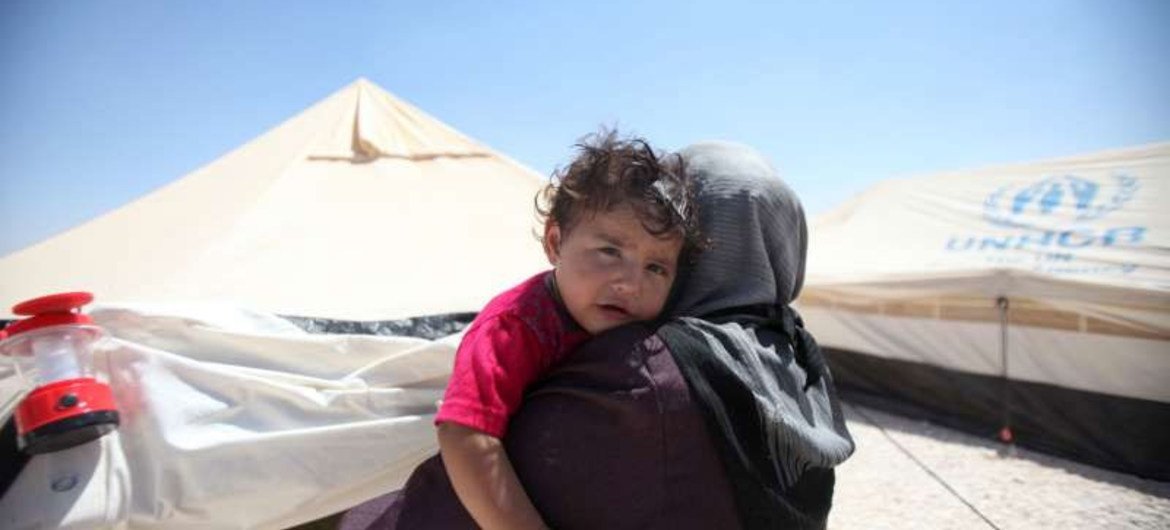 A Syrian refugee woman holds her child in Jordan's Zaátri camp, where the needs are many.