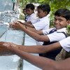 des enfants se lavent les mains à leur école à Bhatri, en Inde.