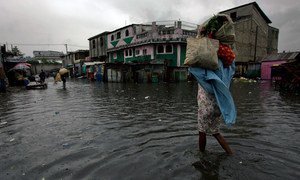 A woman walks through a flooded market in Port au Prince.