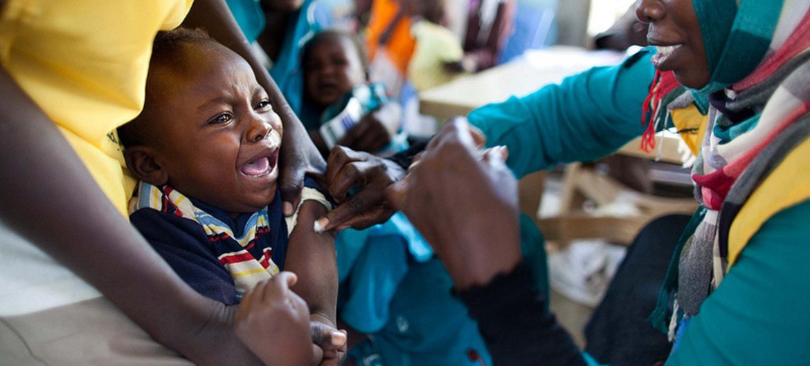 A child receives a vaccine at a community center in Al Neem camp for IDPs in El Daein, East Darfur.