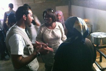 Ertharin Cousin talks with Syrian refugee women in a kitchen set up by WFP at the Zaatari refugee camp in Jordan.