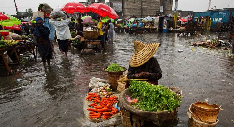 Hurricane Sandy passed to the west of Haiti on 25 October, causing heavy rains and strong winds, flooding homes and overflowing rivers. A woman sells produce at a flooded market place.