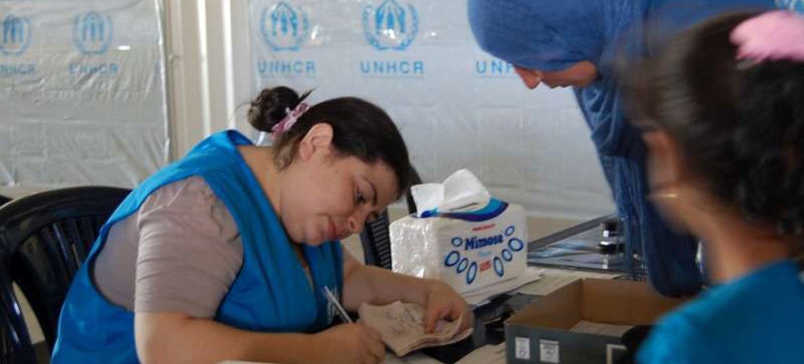 A Syrian refugee registers with a UNHCR staff member in Lebanon to receive assistance.