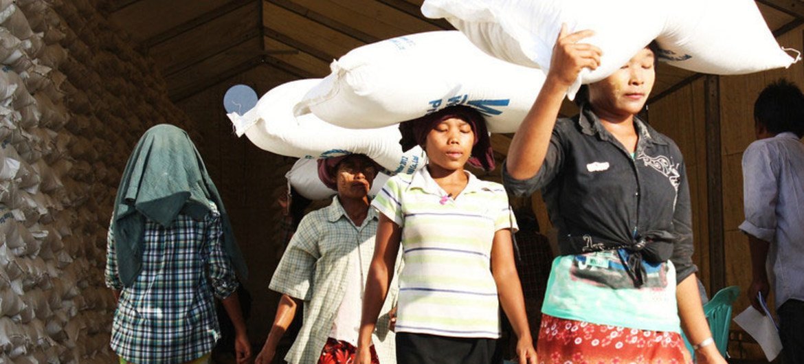 Some of the displaced receive their one-month food ration at the WFP Sittwe distribution warehouse.