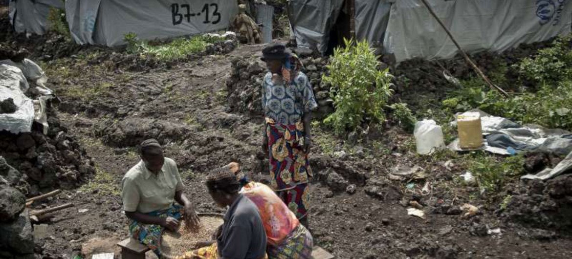 Des femmes déplacées trient des haricots devant leurs abris du camp de Mugunga III, situé dans l'est de la République démocratique du Congo (RDC).