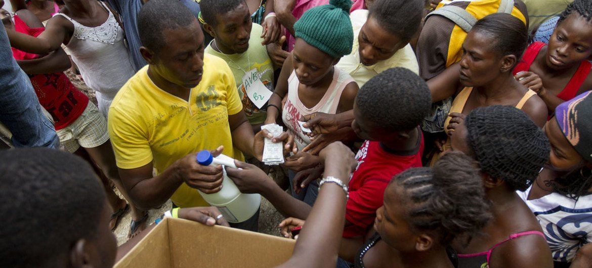 Distribution de comprimés purificateurs d'eau en vue de prévenir l'apparition du choléra dans un camp de déplacés de Port-au-Prince, en Haïti.