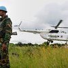 A UN peacekeeper in South Sudan with one of the mission's helicopters.