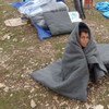 Un jeune réfugié syrien tente de se réchauffer à l'aide d'une couverture au nord de l'Iraq.