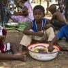Displaced children in the Mali capital, Bamako, eat a welcome meal.