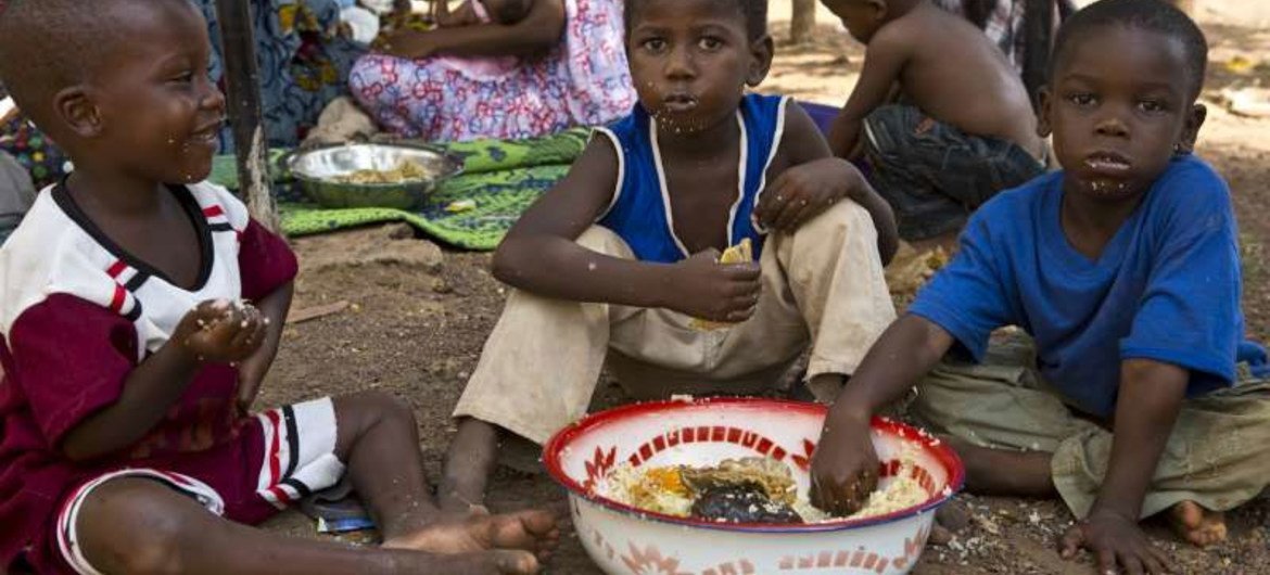 Des enfants déplacés dans la capitale du Mali, Bamako, prennent un repas bienvenu.