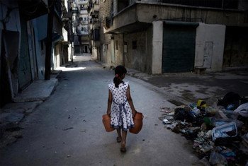 فتاة تحمل الماء في أحد شوارع حلب، سوريا. تصوير اليونيسف/ رومينزي