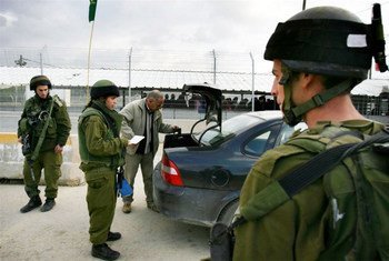 أرشيف: جنود اسرائيليون يفتشون سيارة فلسطينية عند نقطة تفتيش حوارة خارج مدينة نابلس في الضفة الغربية. 