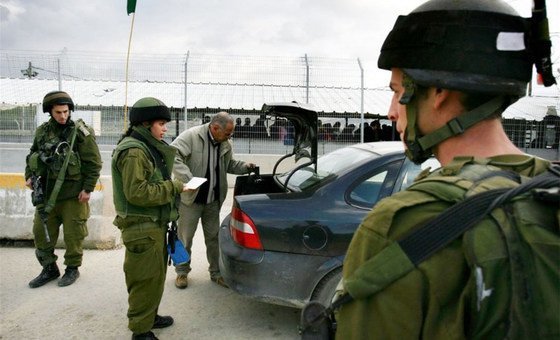 جنود اسرائيليون يفتشون سيارة فلسطينية عند نقطة تفتيش حوراة خارج مدينة نابلس في الضفة الغربية. 