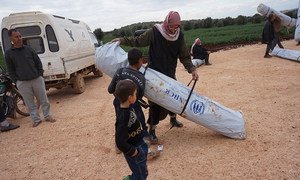 Un homme et son fils transportent leur nouvelle tente dans le camp de déplacés de Kerama, dans le nord de la Syrie.
