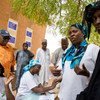 Le Directeur exécutif du Programme alimentaire mondial (PAM), au cours d'une visite dans le village de Tolkobey, au Niger, où des mères allaitantes se voient remettre des céréales enrichies.