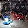 Solar lantern in use by a refugee woman and a girl.