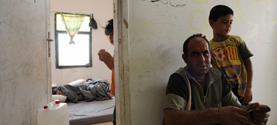 Un enfant et son père à Cyber City, un lieu d'accueil destiné aux réfugiés syriens, située à Raltha, en Jordanie.