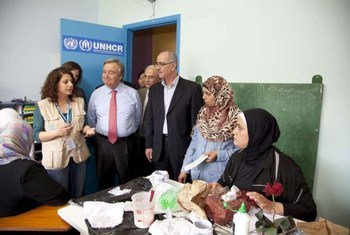 High Commissioner for Refugees António Guterres (in tie) and UNHCR staff talking to Syrian women.