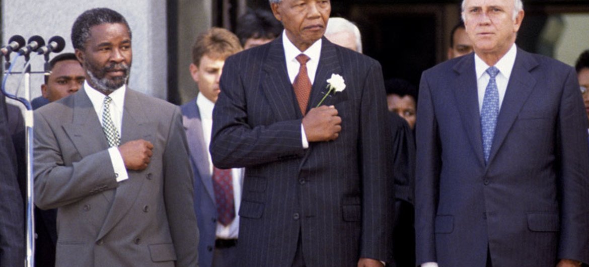 Le président Nelson Mandela (au centre) lors de la cérémonie d'inauguration, après avoir prêté serment en 1994. À sa gauche se trouve Thabo Mbeki et à sa droite Frederik W. de Clerk. 