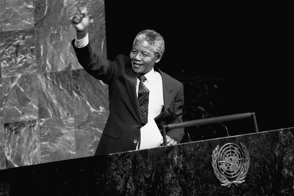 نيلسون مانديلا يرفع قبضته في الهواء أثناء كلمته أمام اللجنة الخاصة لمناهضة الفصل العنصري في قاعة الجمعية العامة عندما كان نائبا لرئيس المؤتمر الوطني الأفريقي لجنوب إفريقيا. 22 حزيران/يونيه 1990.