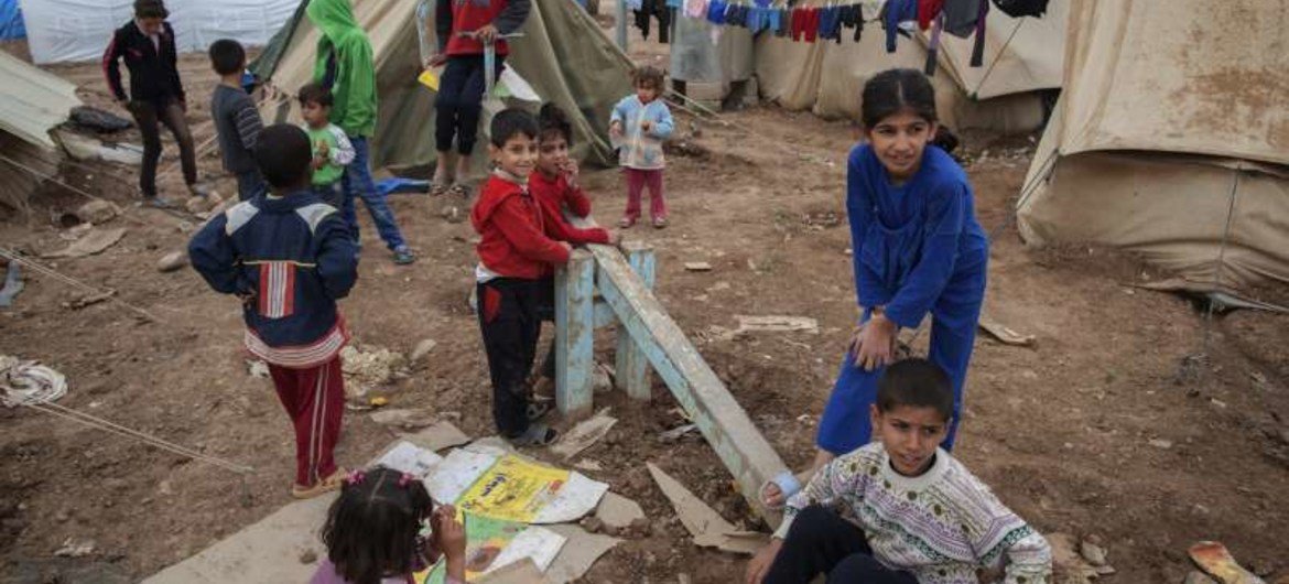 Displaced Syrian children play among tents at the Domiz refugee camp.