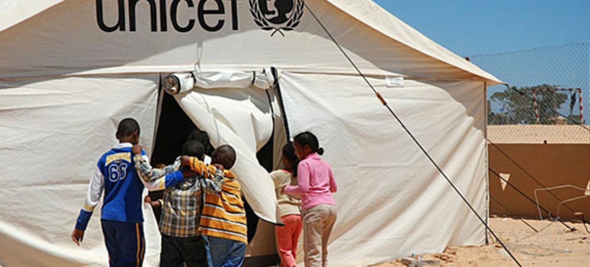 Children enter a UNICEF-supported tent school at the Shousha transit camp on the Libyan border with Tunisia. UNICEF/Heifel Ben Youssef
