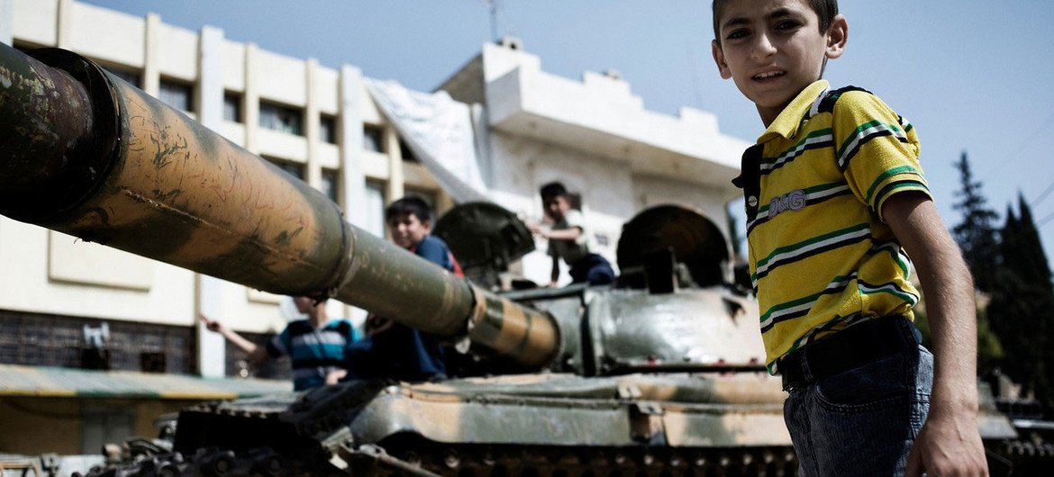 Boys play on a destroyed Syrian army tank in north-western Aleppo.