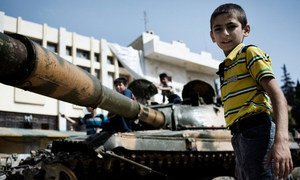 Boys play on a destroyed Syrian army tank in north-western Aleppo.
